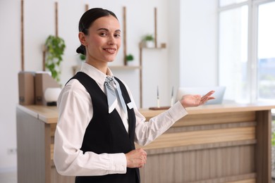 Photo of Portrait of smiling receptionist welcoming in hotel