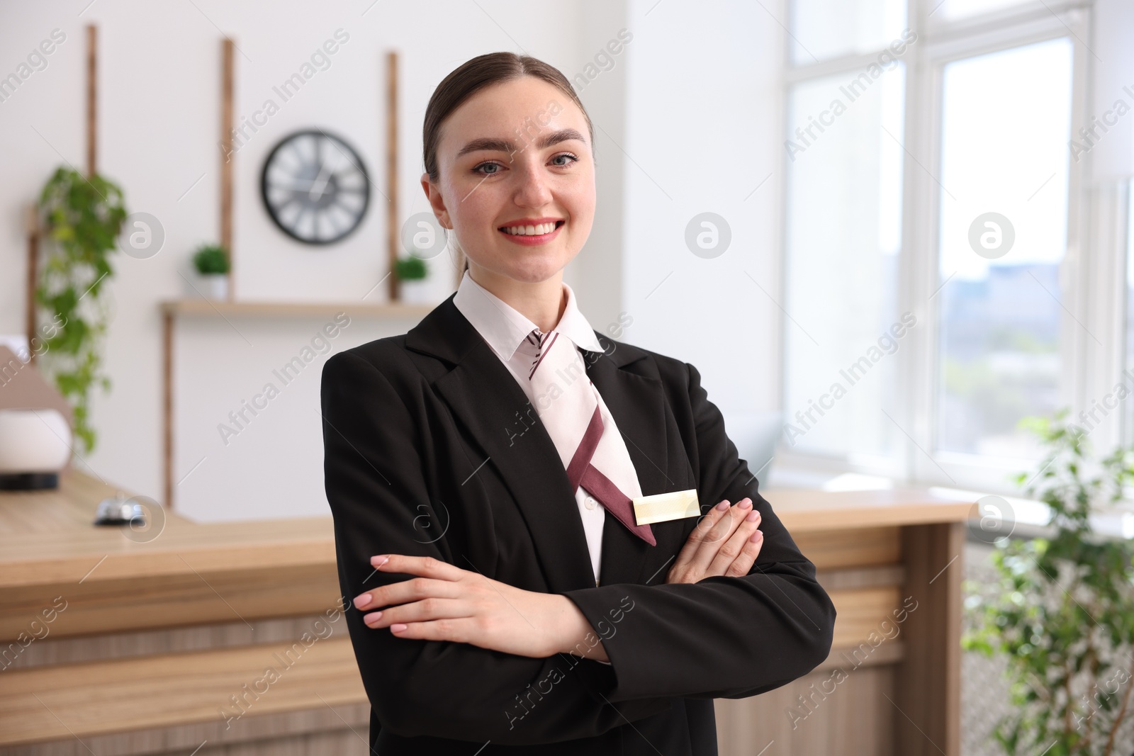 Portrait of smiling receptionist with crossed arms in hotel Photo of Portrait of smiling receptionist with crossed arms in hotel