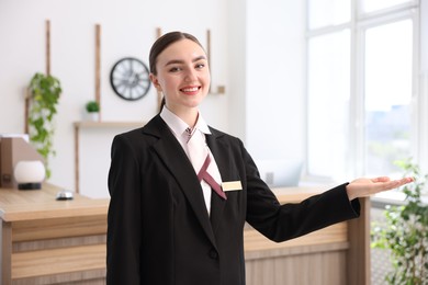 Photo of Portrait of smiling receptionist welcoming in hotel