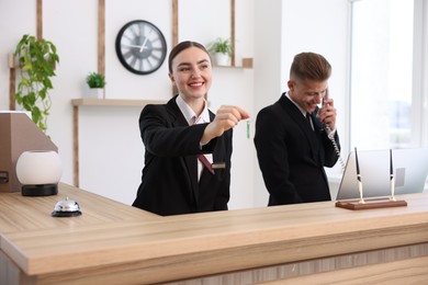 Photo of Smiling receptionists working at reception desk in hotel