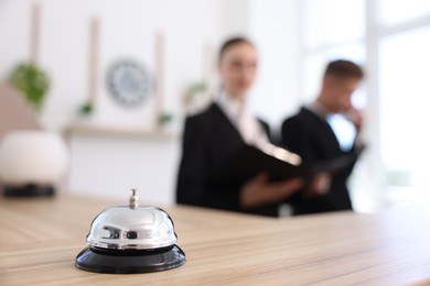 Photo of Receptionists working in hotel, focus on service bell