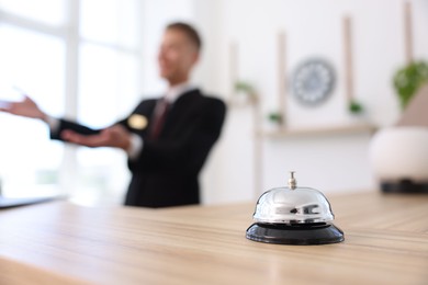 Photo of Receptionist working in hotel, focus on service bell