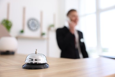 Photo of Receptionist working in hotel, focus on service bell