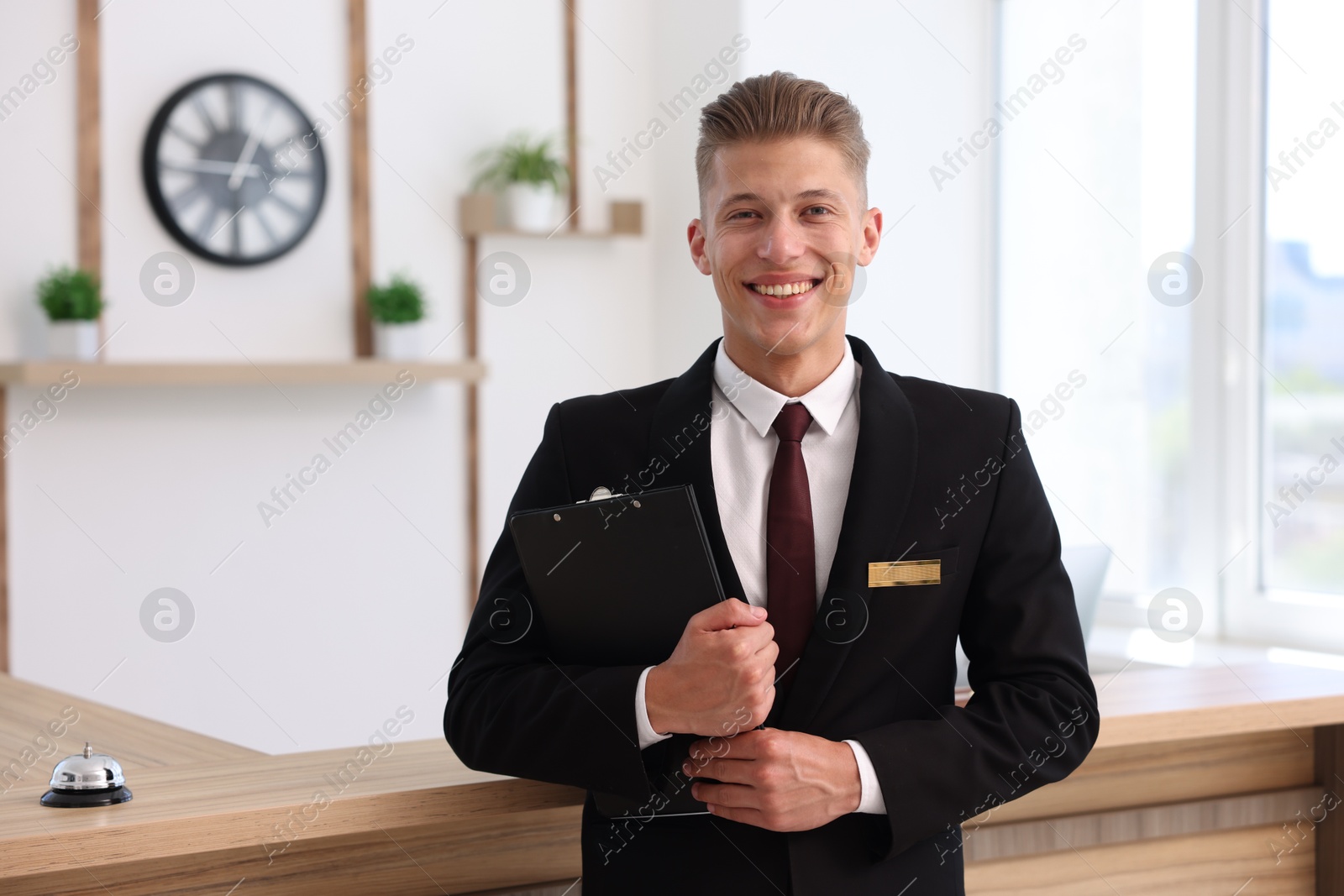 Portrait of smiling receptionist with clipboard in hotel Photo of Portrait of smiling receptionist with clipboard in hotel