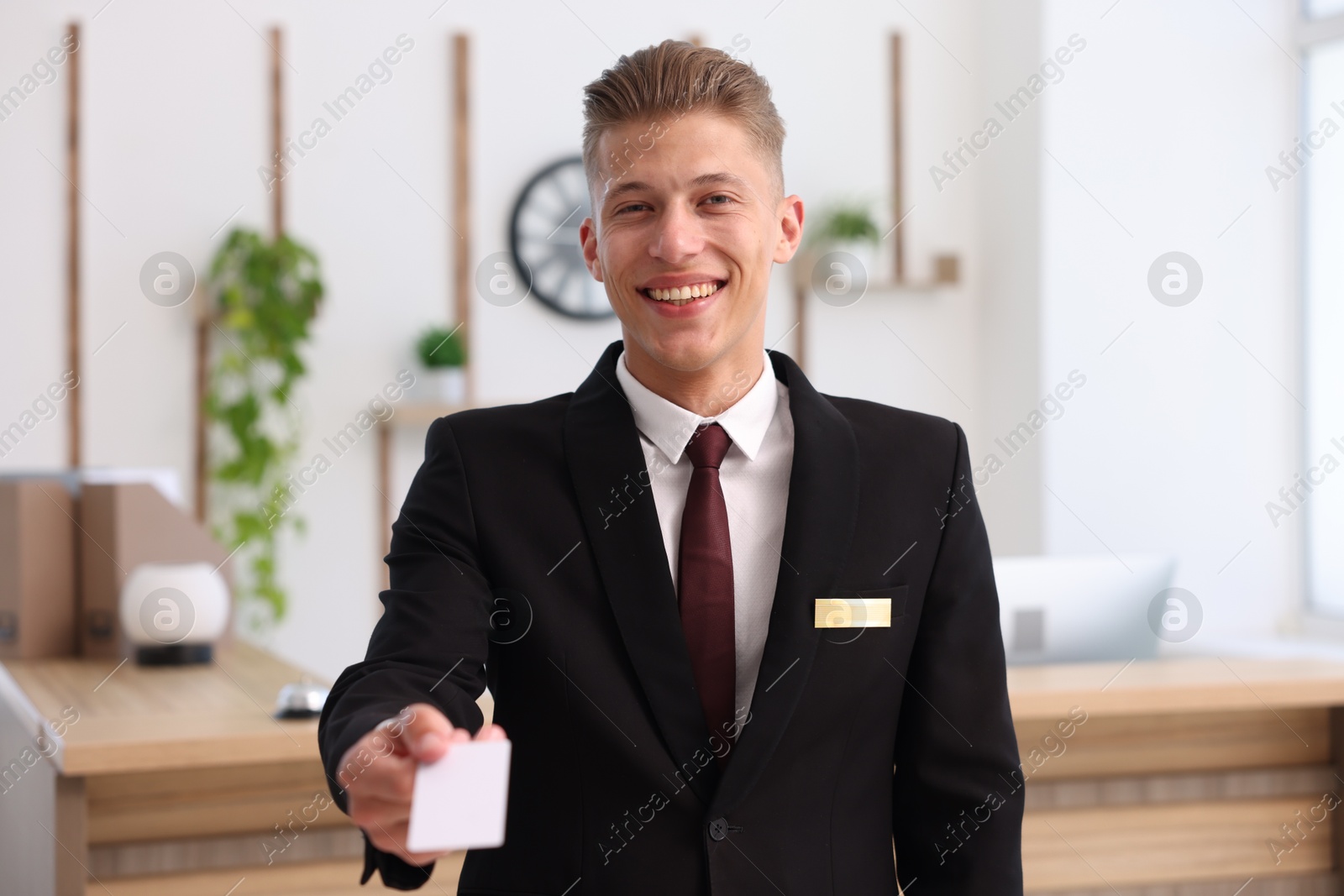 Smiling receptionist in uniform giving key card in hotel Photo of Smiling receptionist in uniform giving key card in hotel