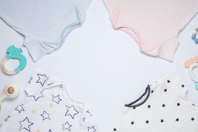 Photo of Frame made of baby clothes and accessories on white background, flat lay. Space for text