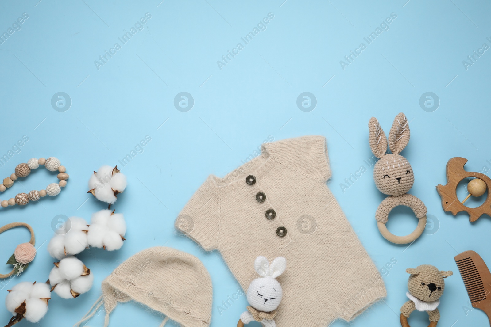 Baby clothes, cotton flowers and accessories on light blue background, flat lay. Space for text Photo of Baby clothes, cotton flowers and accessories on light blue background, flat lay. Space for text