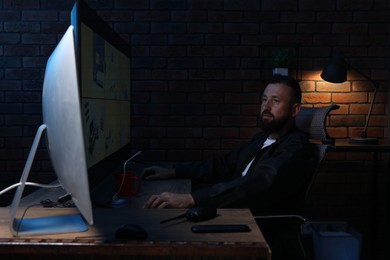 Photo of Security guard monitoring CCTV cameras in office at night