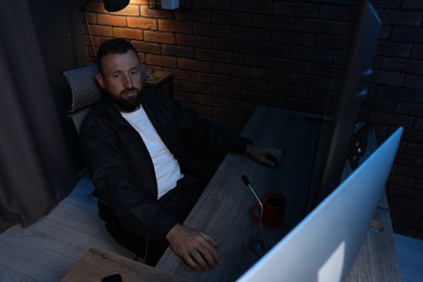 Photo of Security guard monitoring CCTV cameras in office at night