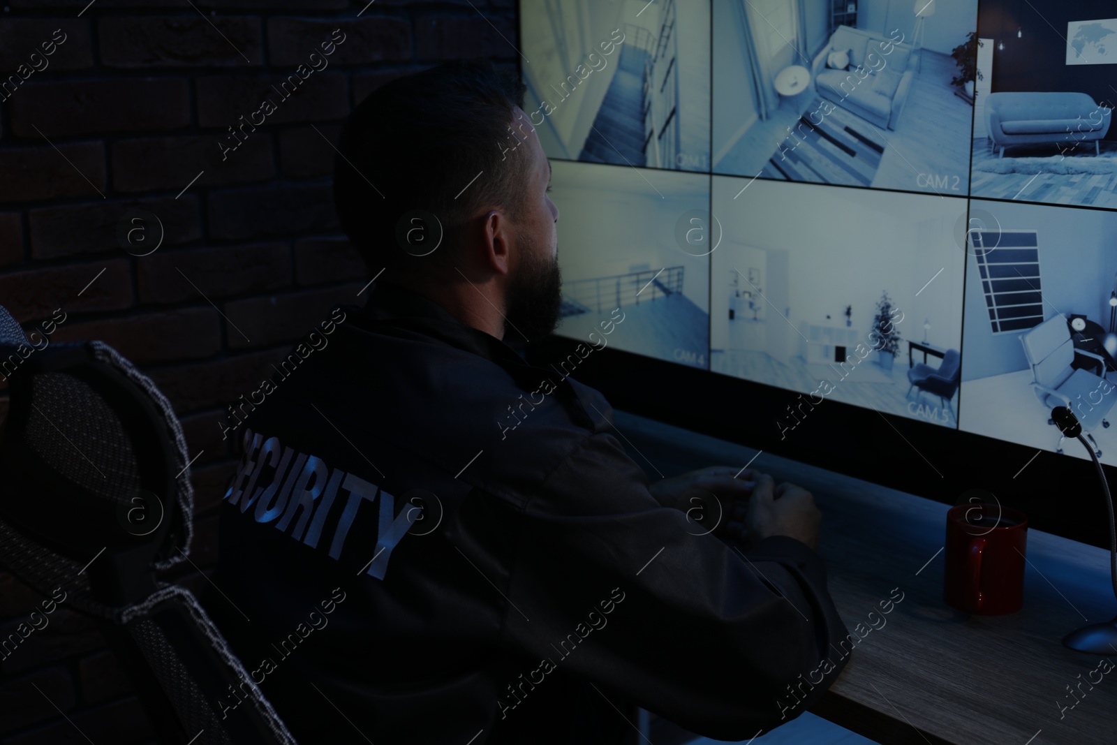 Security guard monitoring CCTV cameras in office at night Photo of Security guard monitoring CCTV cameras in office at night