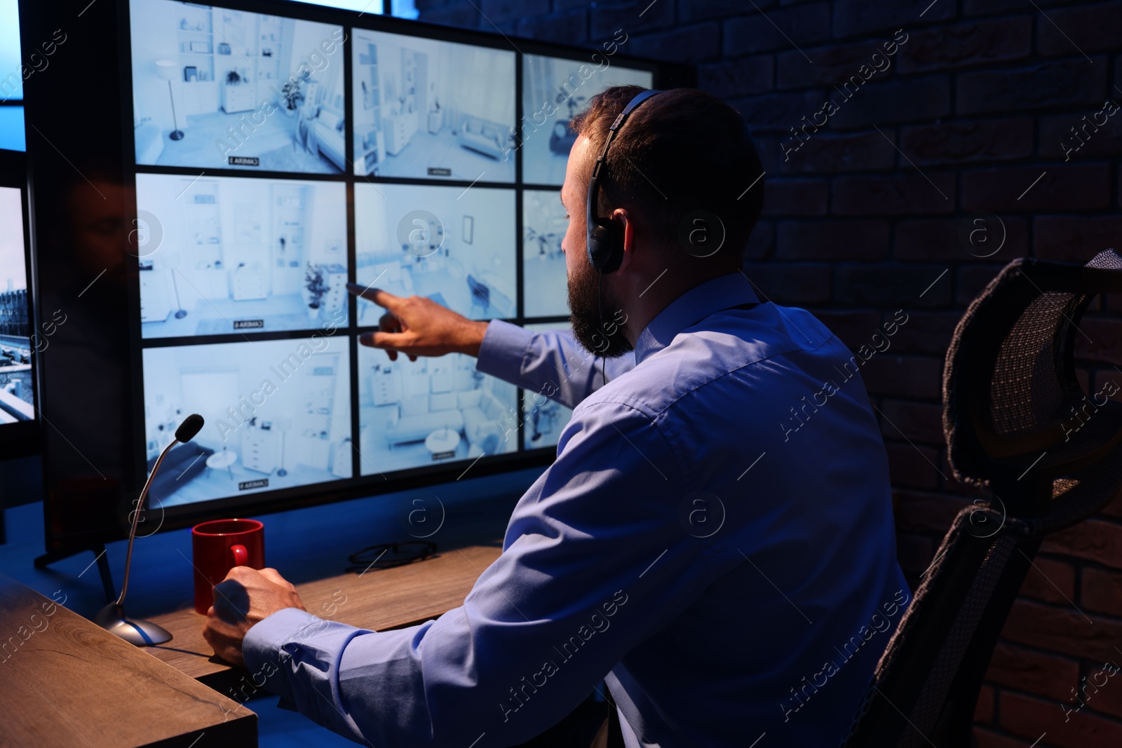 Security guard monitoring CCTV cameras in office at night Photo of Security guard monitoring CCTV cameras in office at night