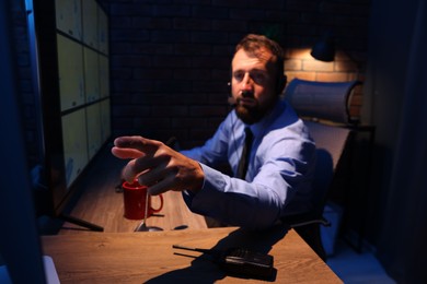 Photo of Security guard monitoring CCTV cameras in office at night