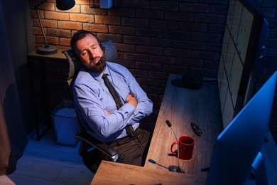 Photo of Sleeping security guard near CCTV cameras in office at night