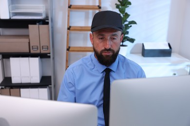 Photo of Security guard monitoring CCTV cameras in office