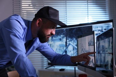 Photo of Security guard monitoring CCTV cameras in office