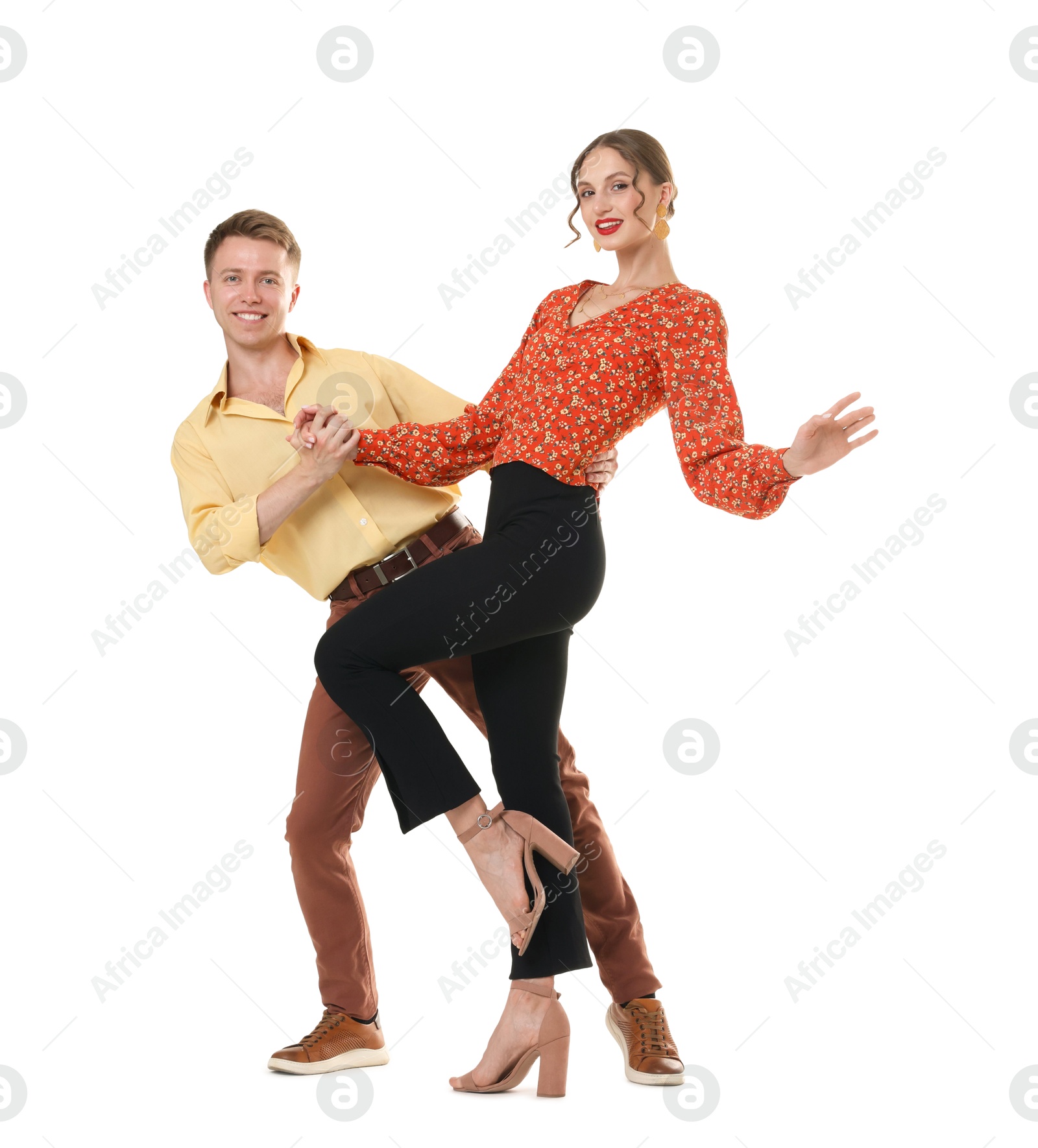 Happy couple in retro outfits dancing on white background Photo of Happy couple in retro outfits dancing on white background