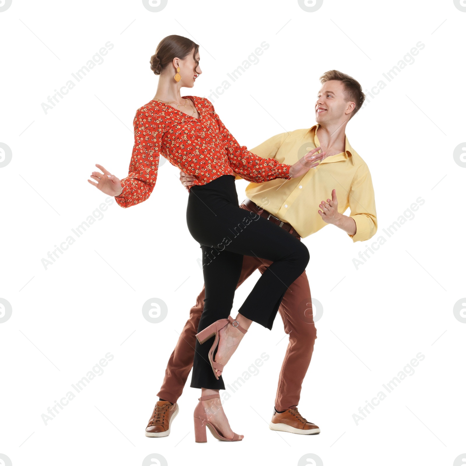 Happy couple in retro outfits dancing on white background Photo of Happy couple in retro outfits dancing on white background