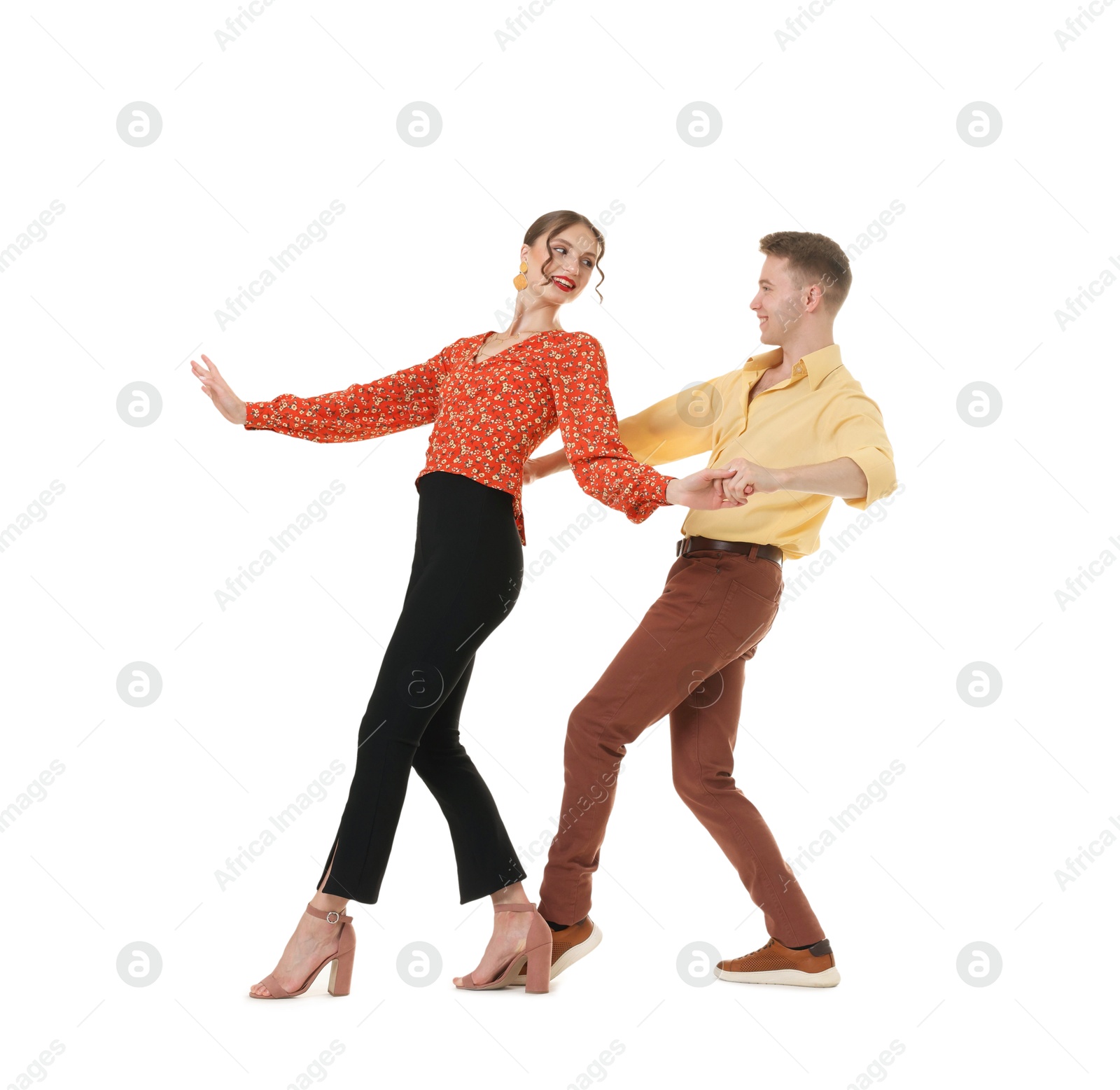 Photo of Happy couple in retro outfits dancing on white background