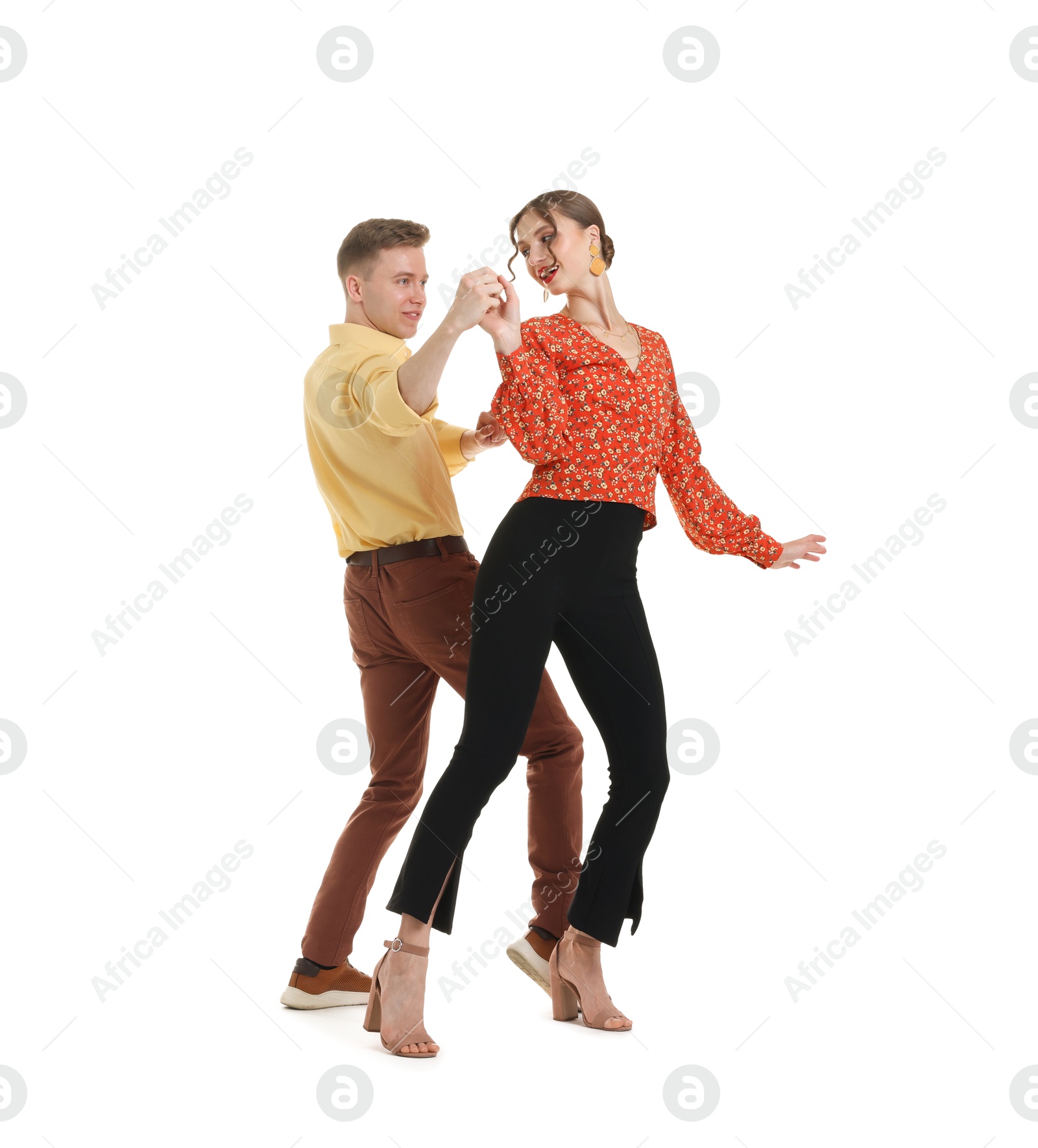Happy couple in retro outfits dancing on white background Photo of Happy couple in retro outfits dancing on white background