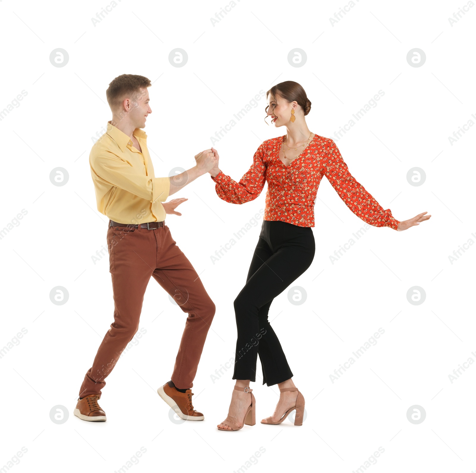 Happy couple in retro outfits dancing on white background Photo of Happy couple in retro outfits dancing on white background