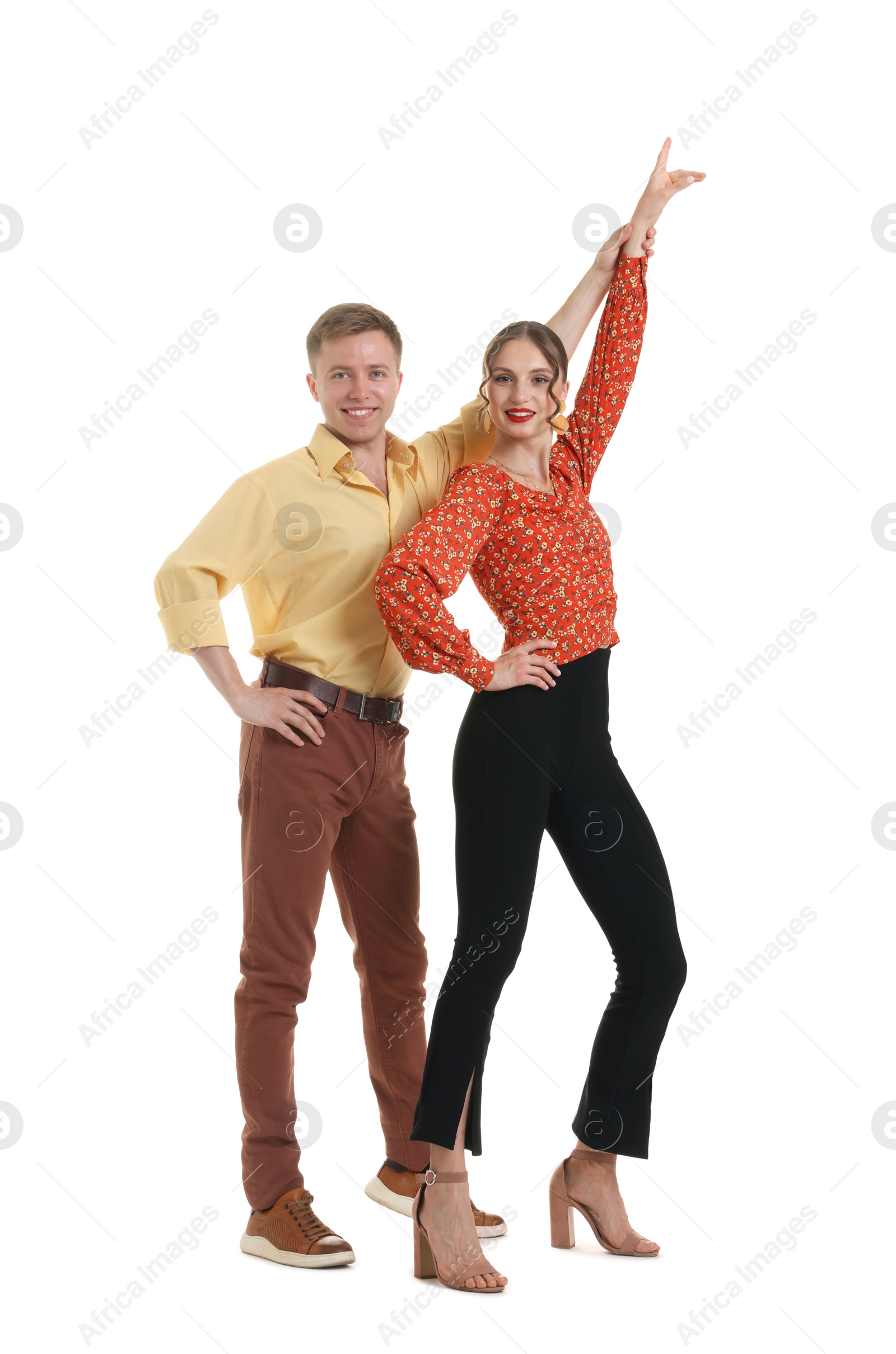 Happy couple in retro outfits dancing on white background Photo of Happy couple in retro outfits dancing on white background