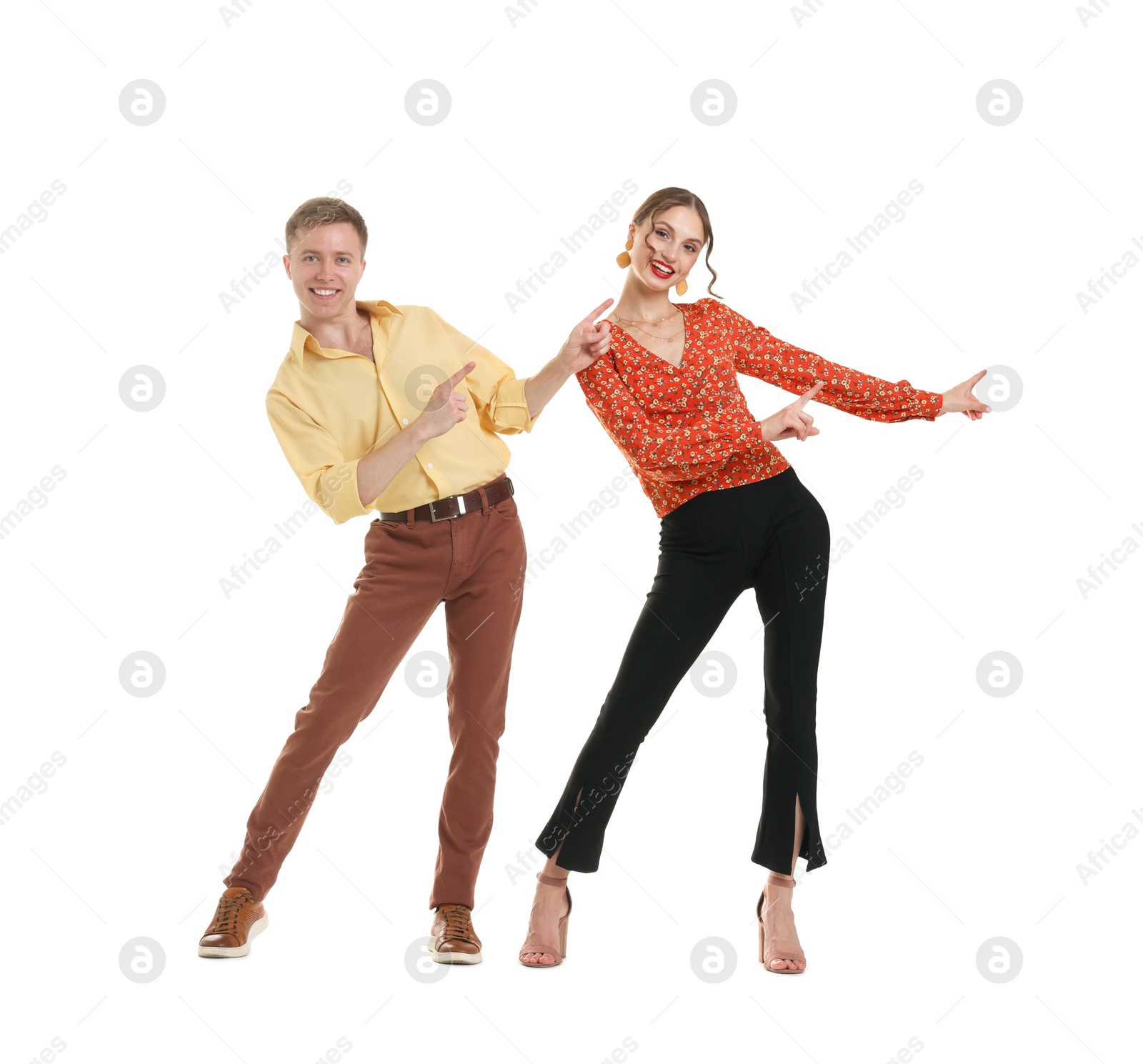 Happy couple in retro outfits dancing on white background Photo of Happy couple in retro outfits dancing on white background