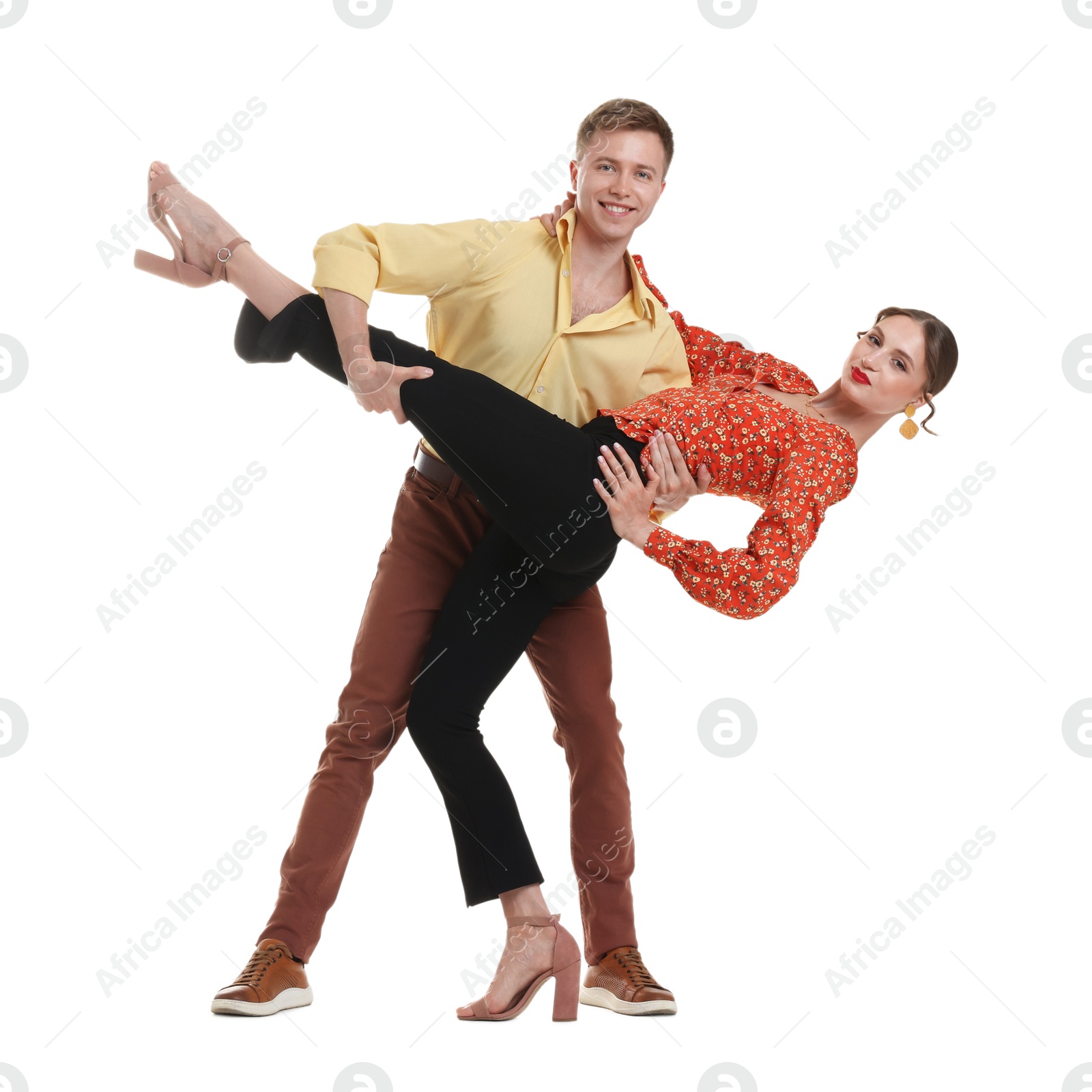 Photo of Happy couple in retro outfits dancing on white background