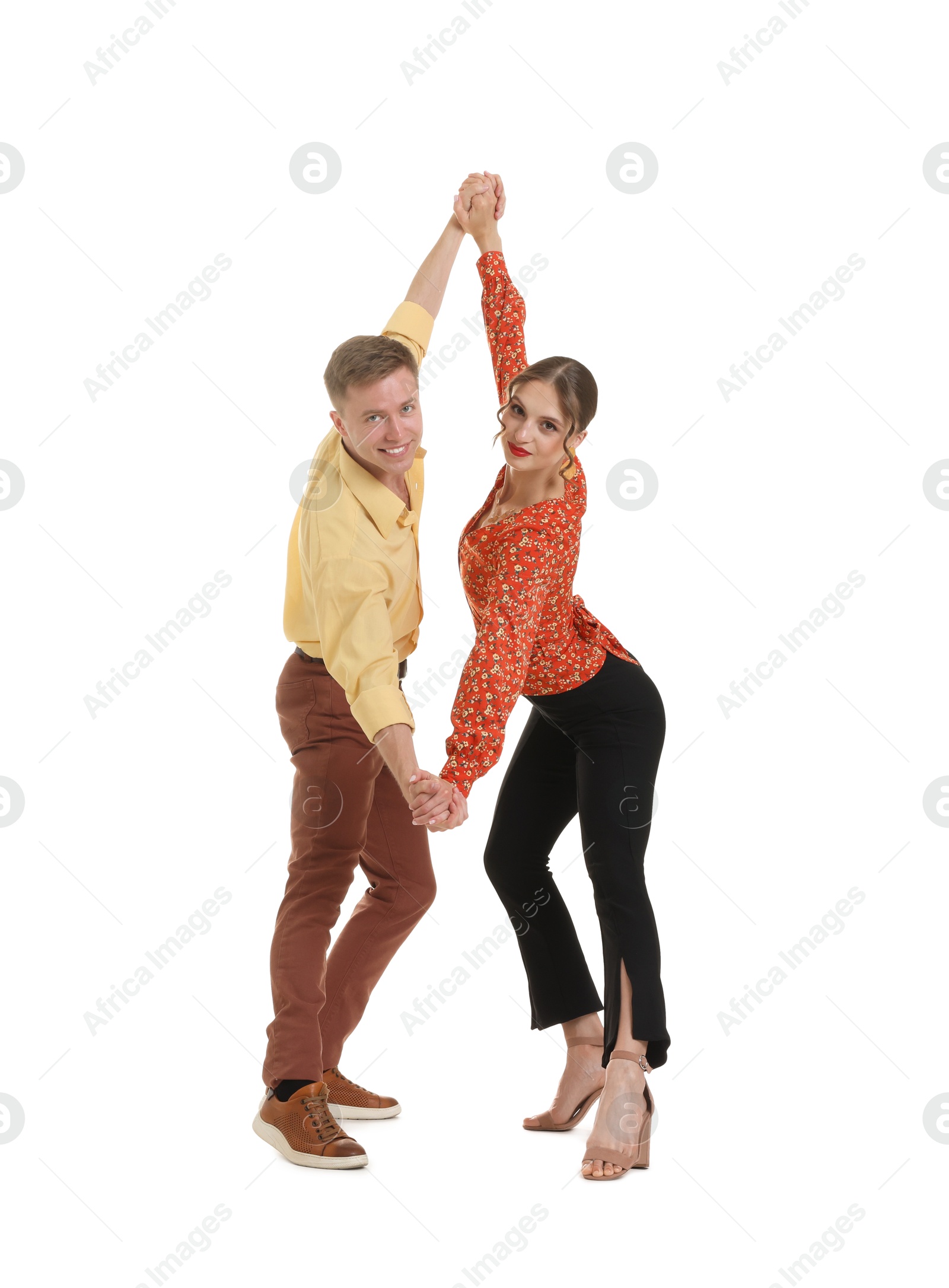 Happy couple in retro outfits dancing on white background Photo of Happy couple in retro outfits dancing on white background