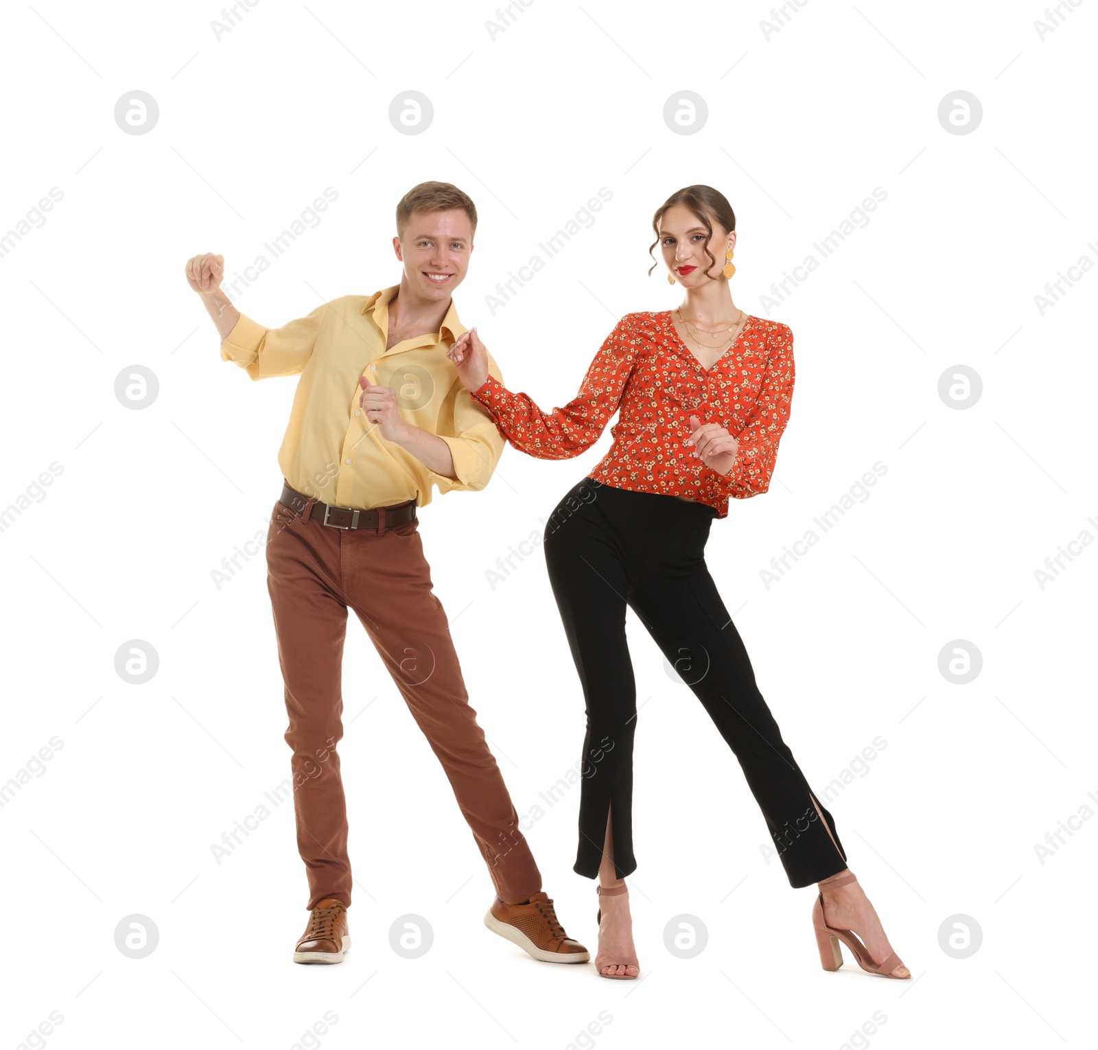 Happy couple in retro outfits dancing on white background Photo of Happy couple in retro outfits dancing on white background