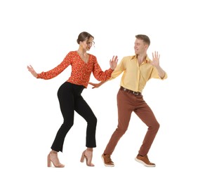 Photo of Happy couple in retro outfits dancing on white background