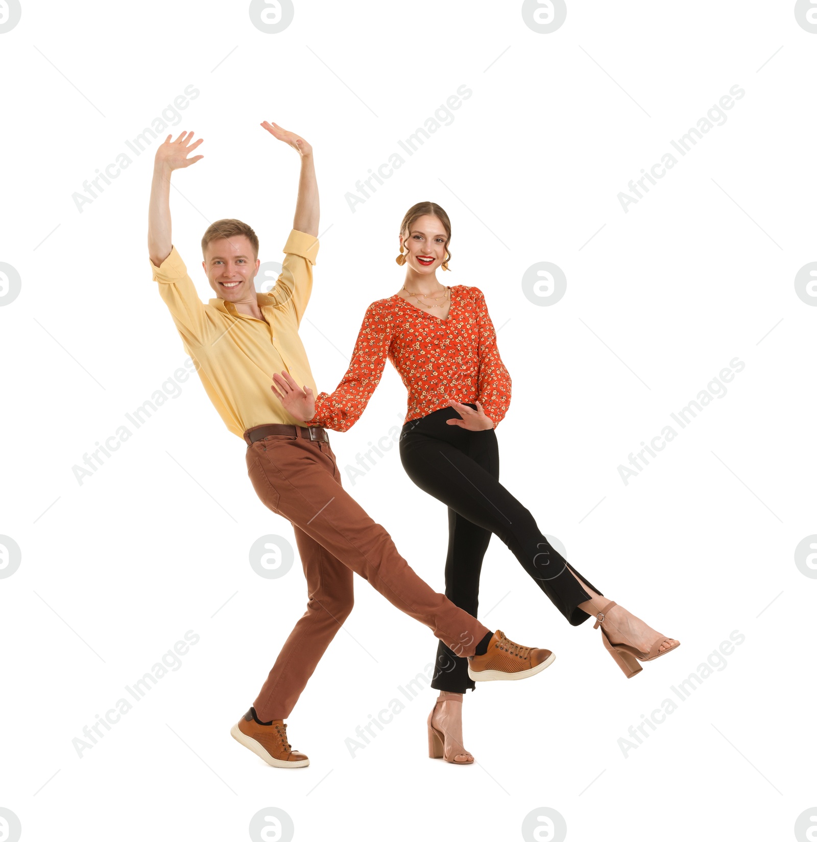 Photo of Happy couple in retro outfits dancing on white background