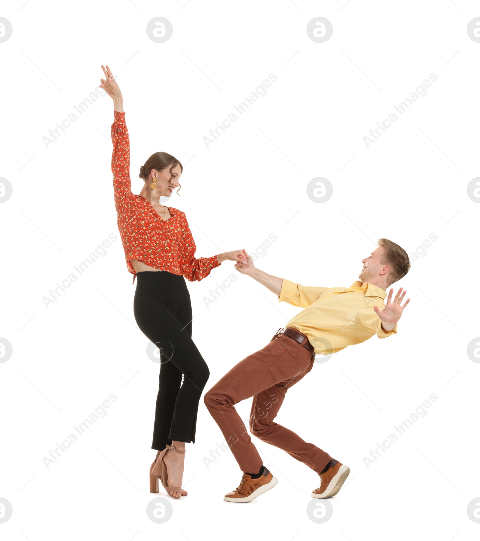 Happy couple in retro outfits dancing on white background Photo of Happy couple in retro outfits dancing on white background