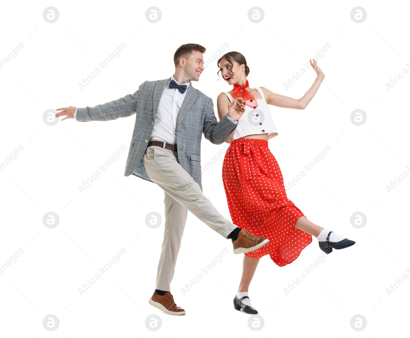 Happy couple in retro outfits dancing on white background Photo of Happy couple in retro outfits dancing on white background
