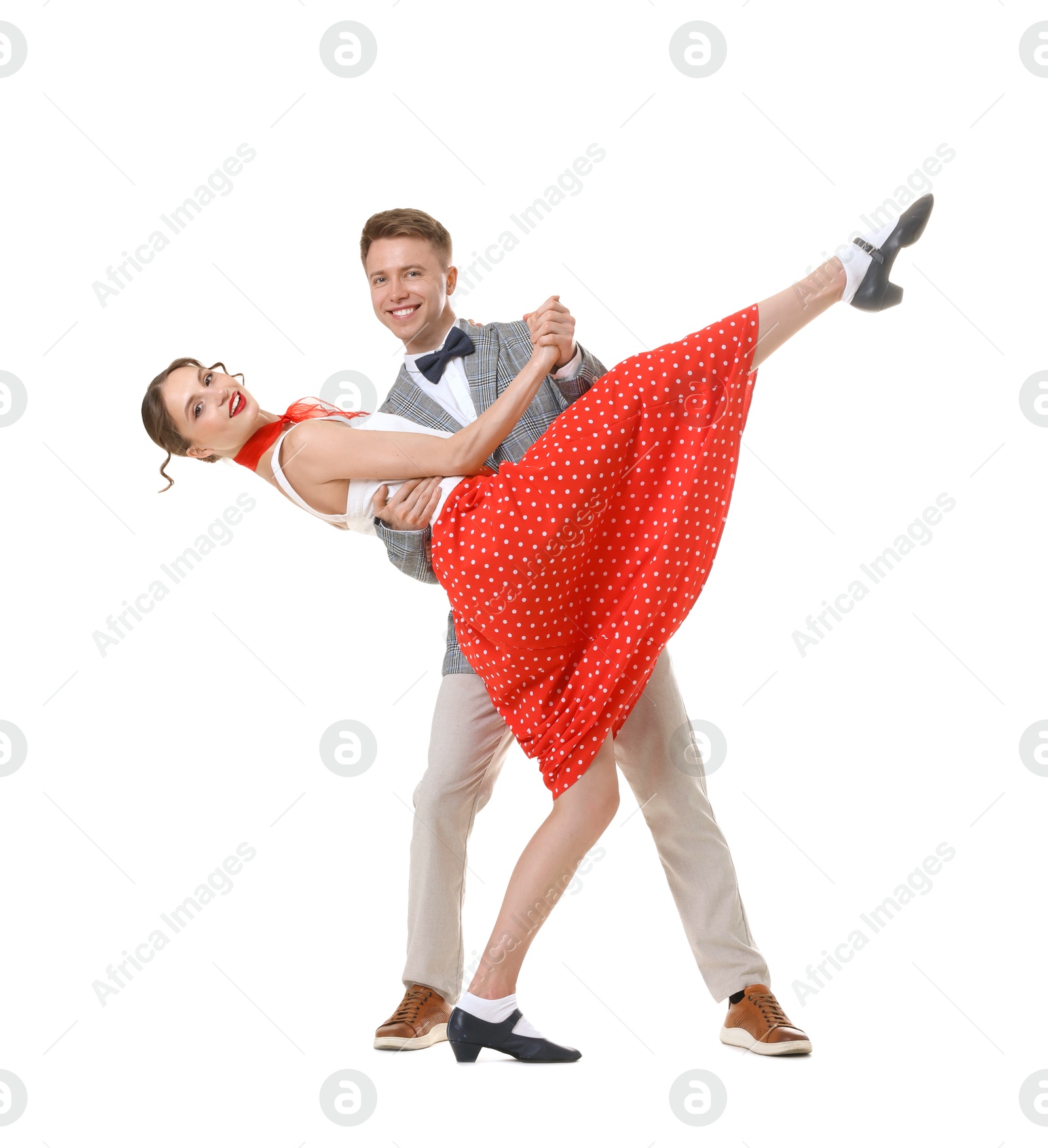 Happy couple in retro outfits dancing on white background Photo of Happy couple in retro outfits dancing on white background