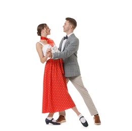 Photo of Happy couple in retro outfits dancing on white background