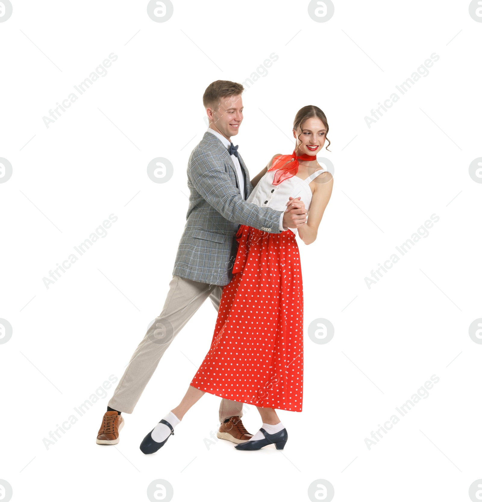 Happy couple in retro outfits dancing on white background Photo of Happy couple in retro outfits dancing on white background