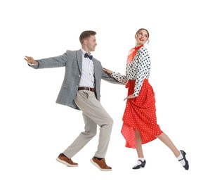 Photo of Happy couple in retro outfits dancing on white background