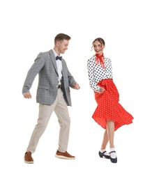 Photo of Happy couple in retro outfits dancing on white background