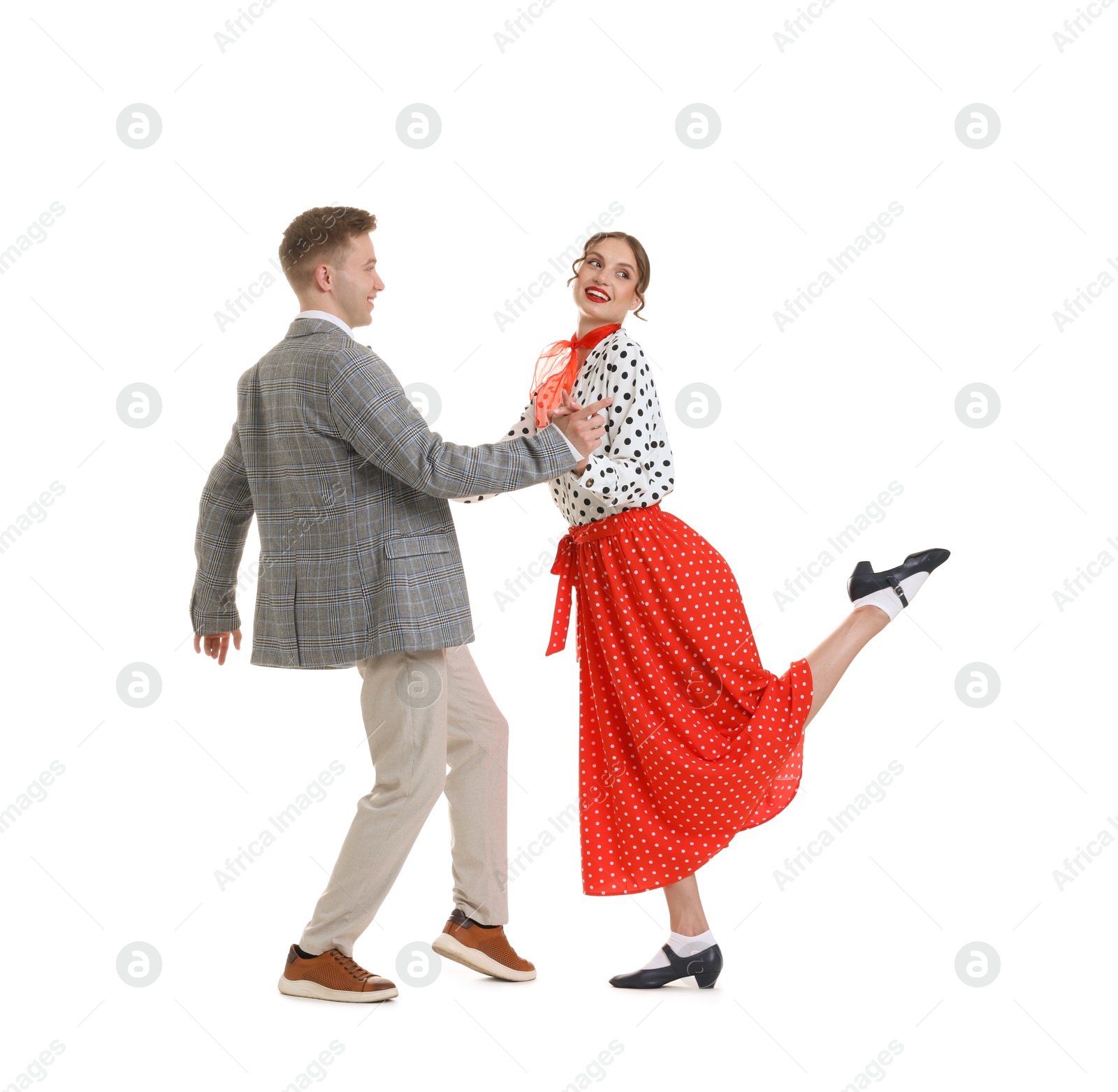Happy couple in retro outfits dancing on white background Photo of Happy couple in retro outfits dancing on white background