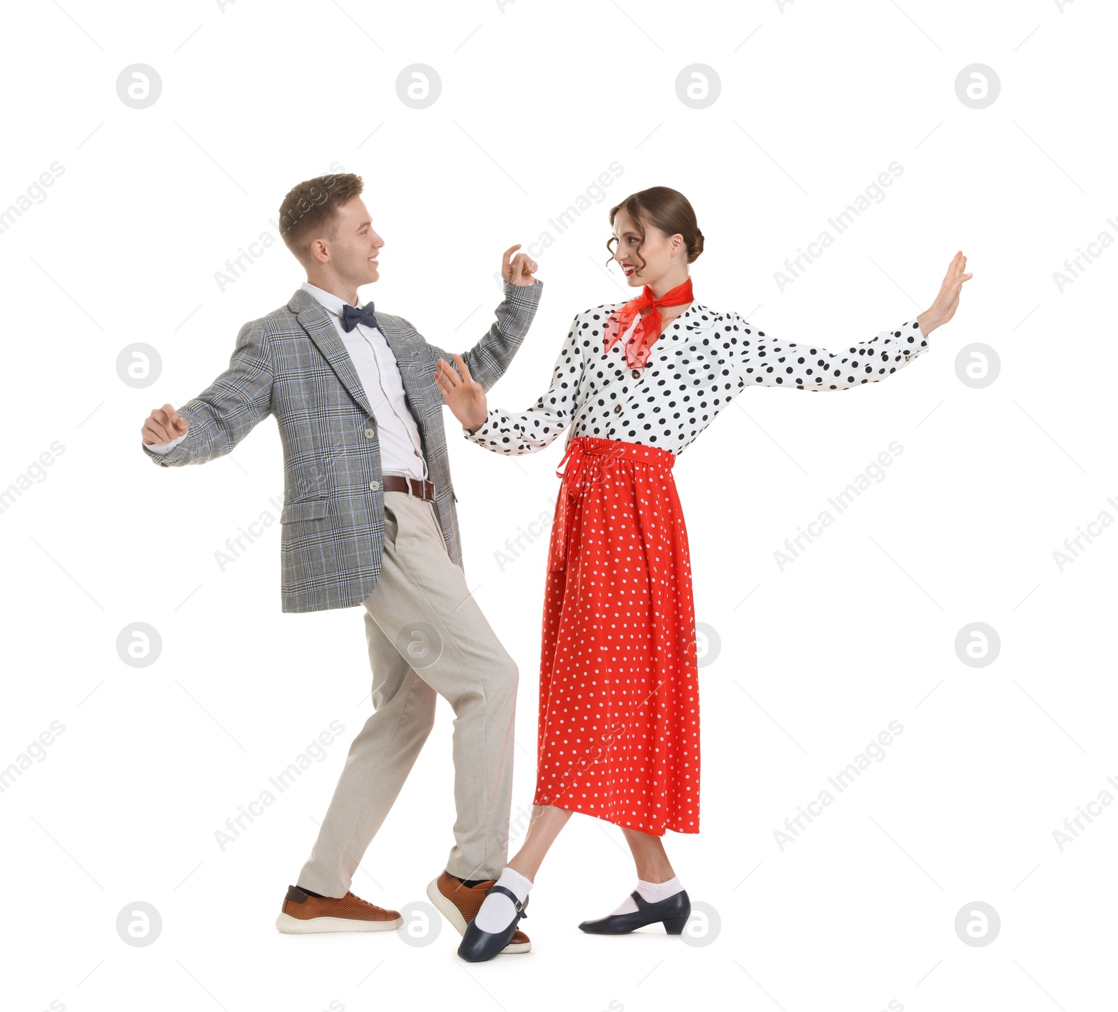 Happy couple in retro outfits dancing on white background Photo of Happy couple in retro outfits dancing on white background