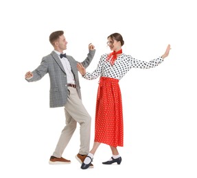 Photo of Happy couple in retro outfits dancing on white background
