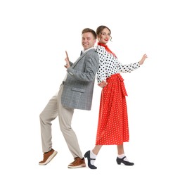Photo of Happy couple in retro outfits dancing on white background
