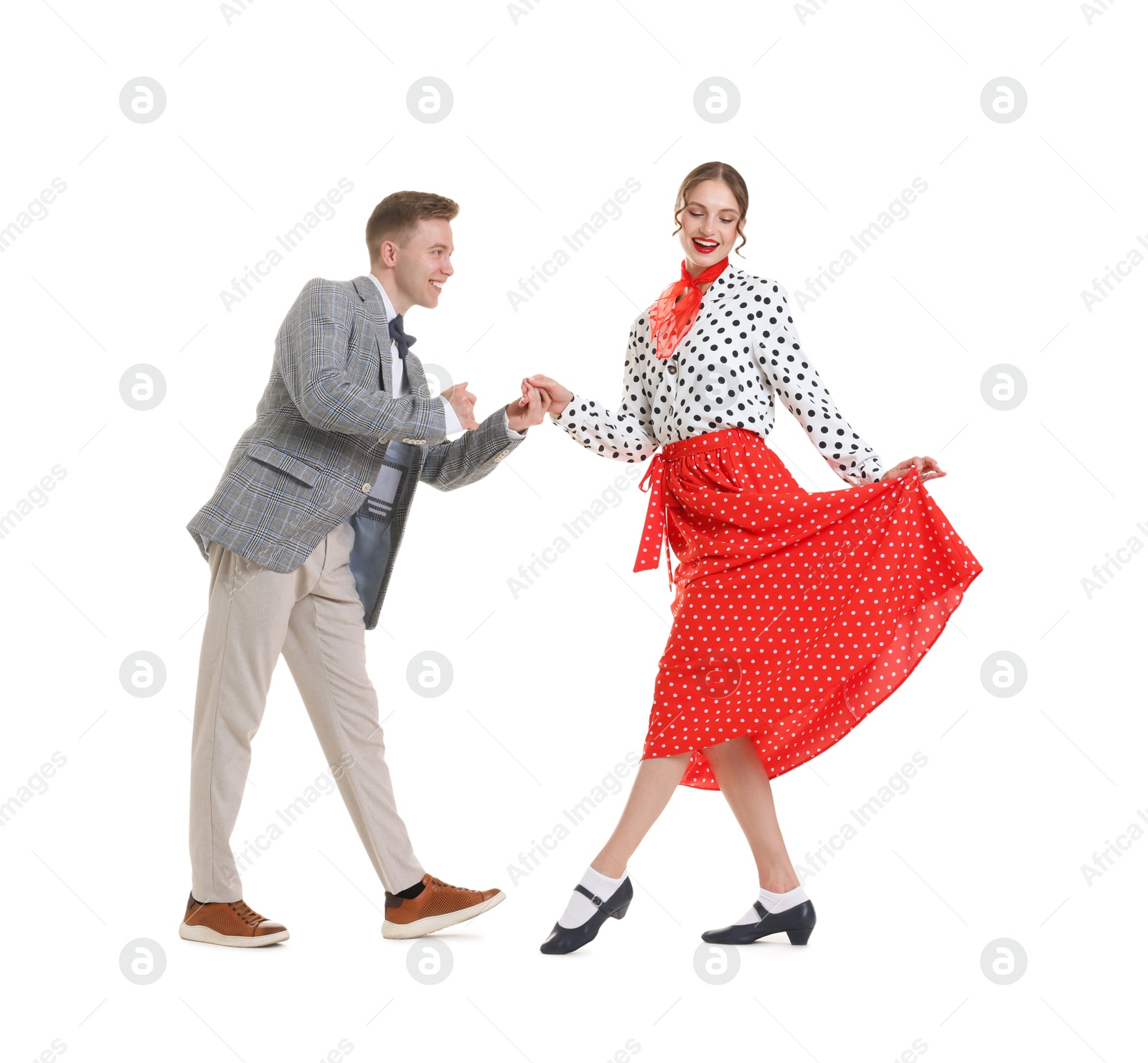 Happy couple in retro outfits dancing on white background Photo of Happy couple in retro outfits dancing on white background