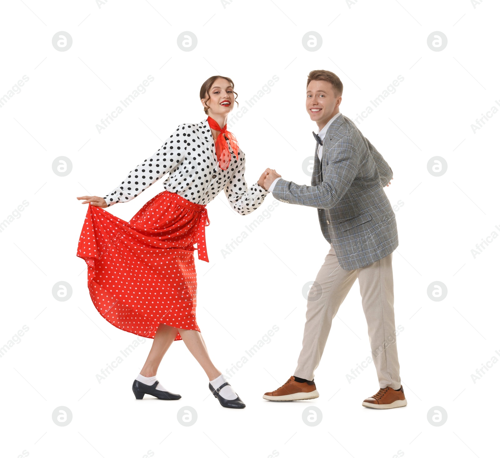 Happy couple in retro outfits dancing on white background Photo of Happy couple in retro outfits dancing on white background
