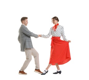 Photo of Happy couple in retro outfits dancing on white background