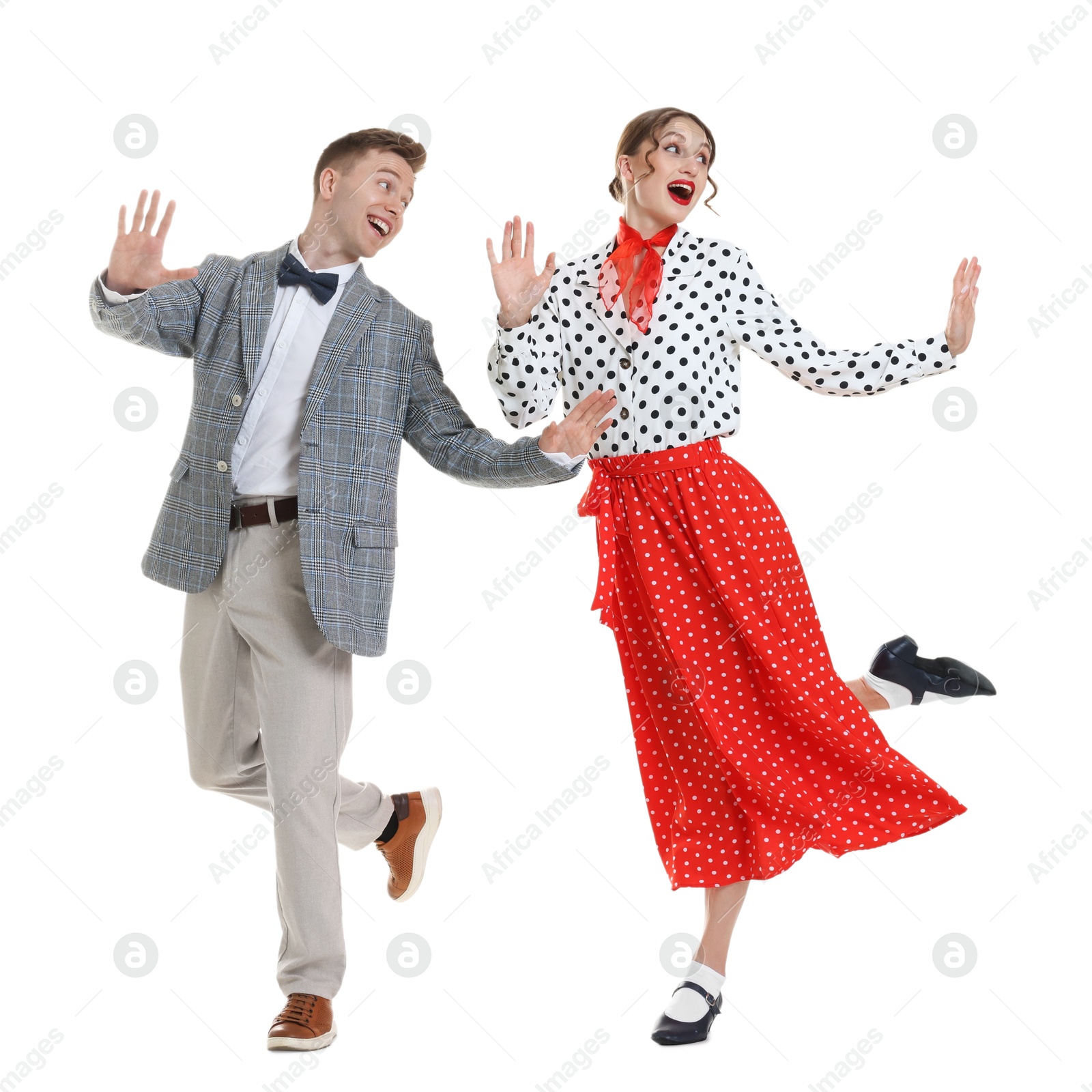 Happy couple in retro outfits dancing on white background Photo of Happy couple in retro outfits dancing on white background