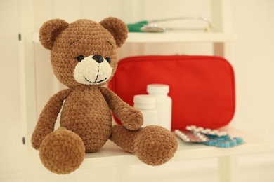 Photo of Pediatrics concept. Toy bear with pills on white background