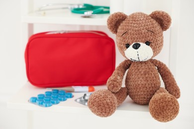 Photo of Pediatrics concept. Toy bear with pills on white background