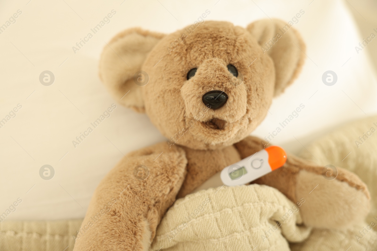 Pediatrics concept. Toy bear with thermometer in bed Photo of Pediatrics concept. Toy bear with thermometer in bed