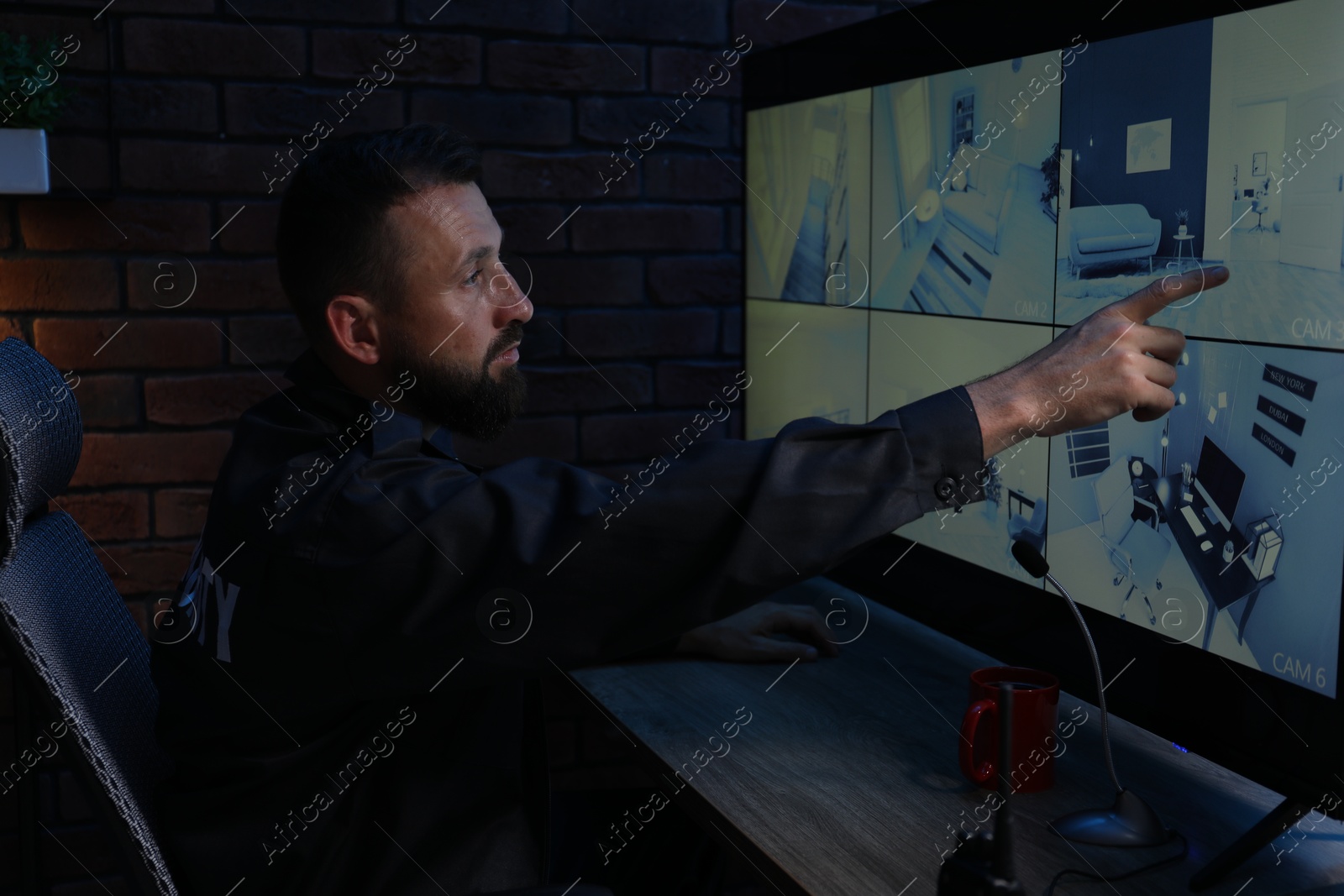 Security guard monitoring CCTV cameras in office at night Photo of Security guard monitoring CCTV cameras in office at night